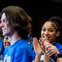 Clapping Thompson Scholar students with blue Thompson Scholar shirts on